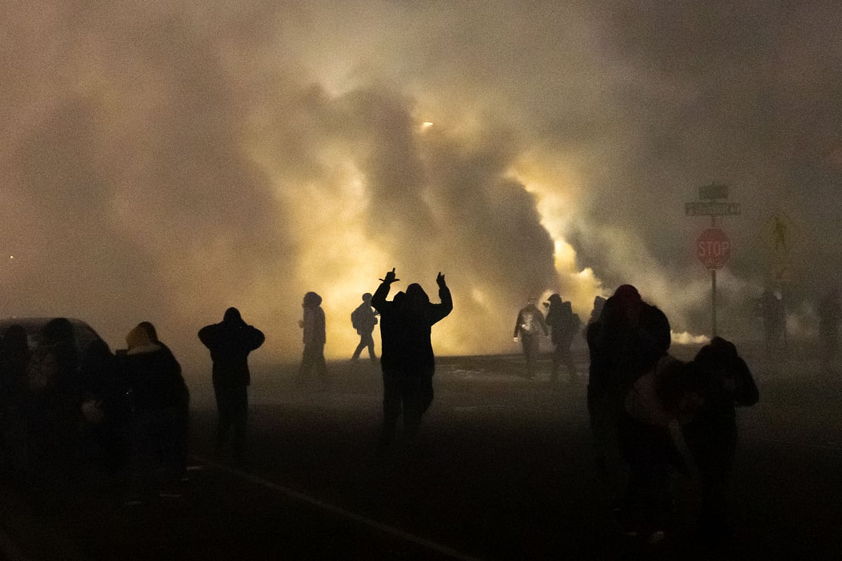 People take cover as police fires tear gas in front of the Brooklyn Center Police Station during a protest after a police officer shot and killed a black man in Brooklyn Center, Minneapolis, Minnesota on 11 April 2021