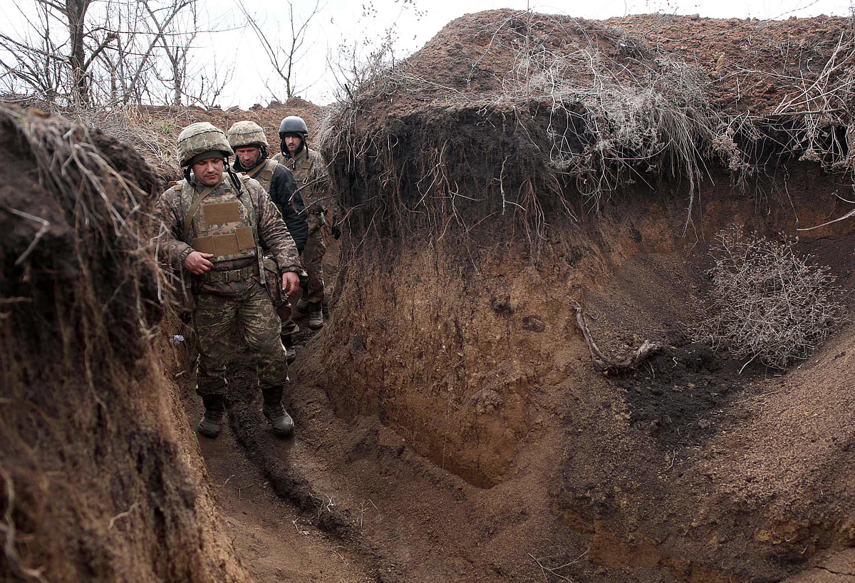 Ukrainian servicemen walk in a trench as they stand at their post on the frontline with Russia backed separatists near the town of Zolote, in the Lugansk region on April, 2021