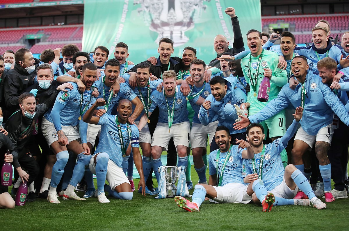 Manchester City players pose with the trophy as they celebrate after winning the Carabao Cup