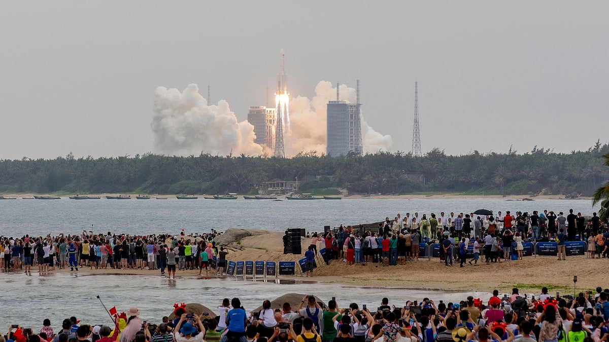 People watch a Long March 5B rocket, which carries China's Tianhe space station core module, lifting off from the Wenchang Space Launch Center, in southern China's Hainan province on 29 April, 2021