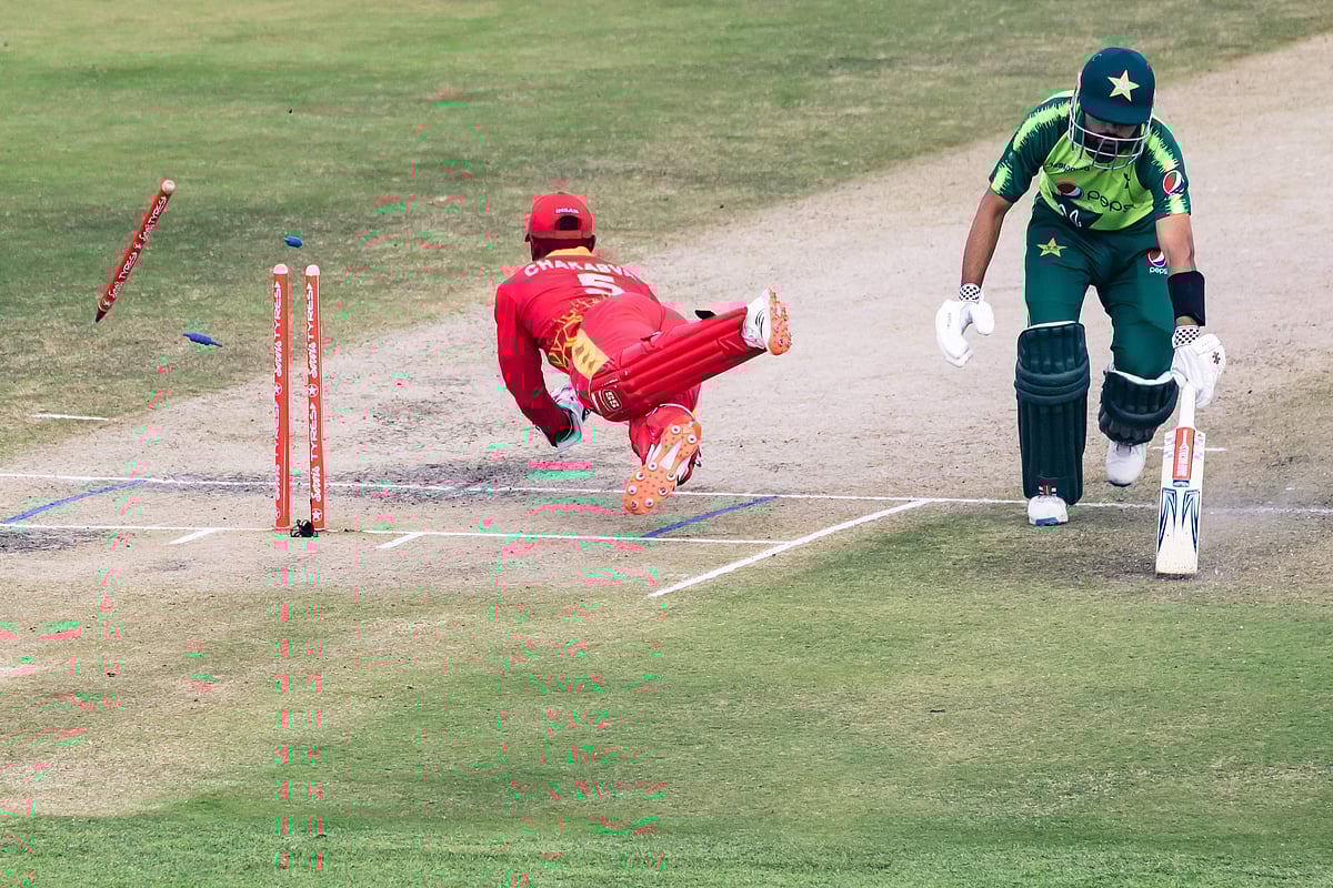 imbabwe's wicketkeeper Regis Chakabva (L) attempts a run-out of Pakistan's Babar Azam (R) during the second Twenty20 international cricket match between Zimbabwe and Pakistan at the Harare Sports Club in Harare on 23 April, 2021