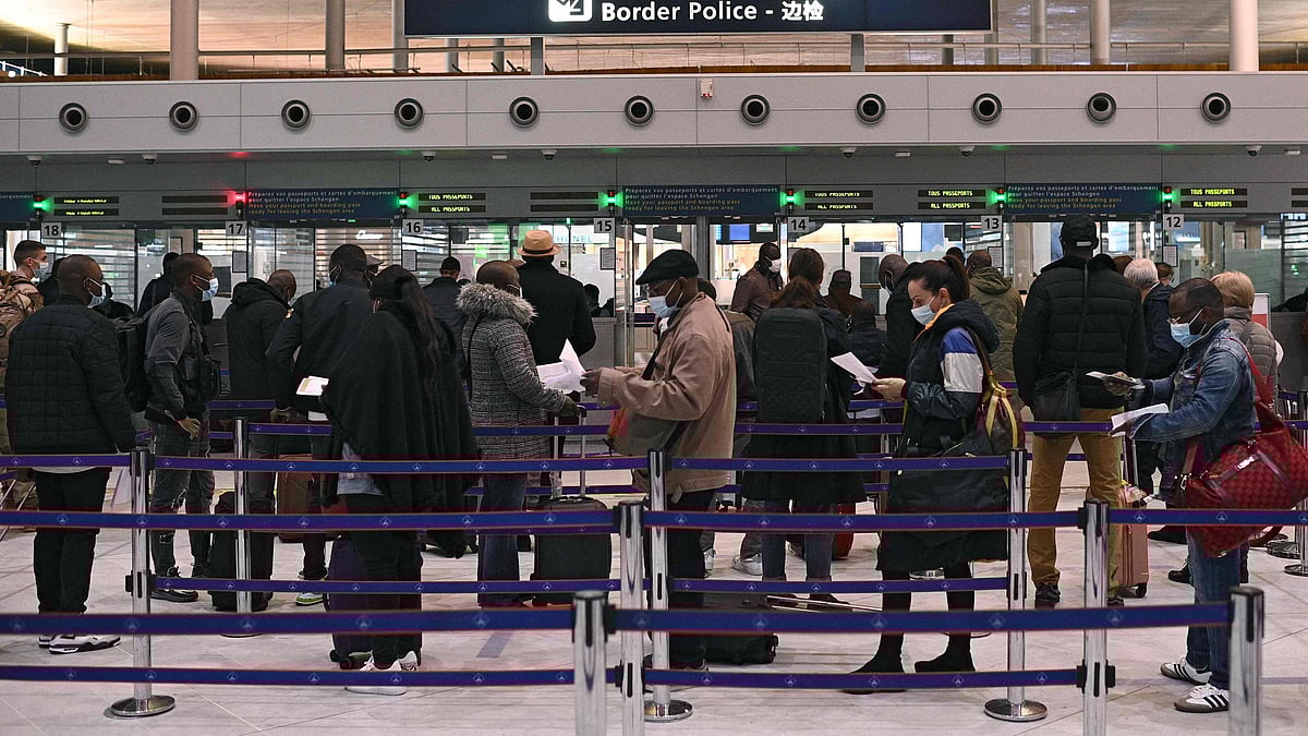 In this file photo taken on 1 February 2021, travellers prepare their documents as they queue at the immigration desk of Roissy Charles-de-Gaulle international airport as new Covid-19 border restrictions come into effect