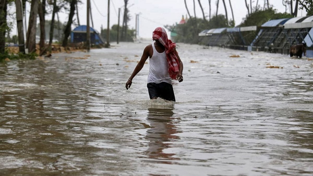 A man wades through a water-logged road after rains ahead of Cyclone Yaas at Digha in Purba Medinipur district in the eastern state of West Bengal, India, on 26 May 2021