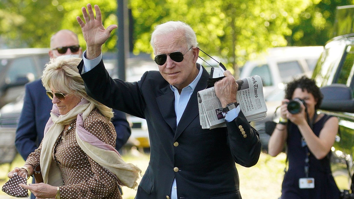 US president Joe Biden waves as he removing his face mask while walking with first lady Jill Biden as they depart from the White House en route to Wilmington, Delaware from the Ellipse in Washington, US, on 15 May 2021