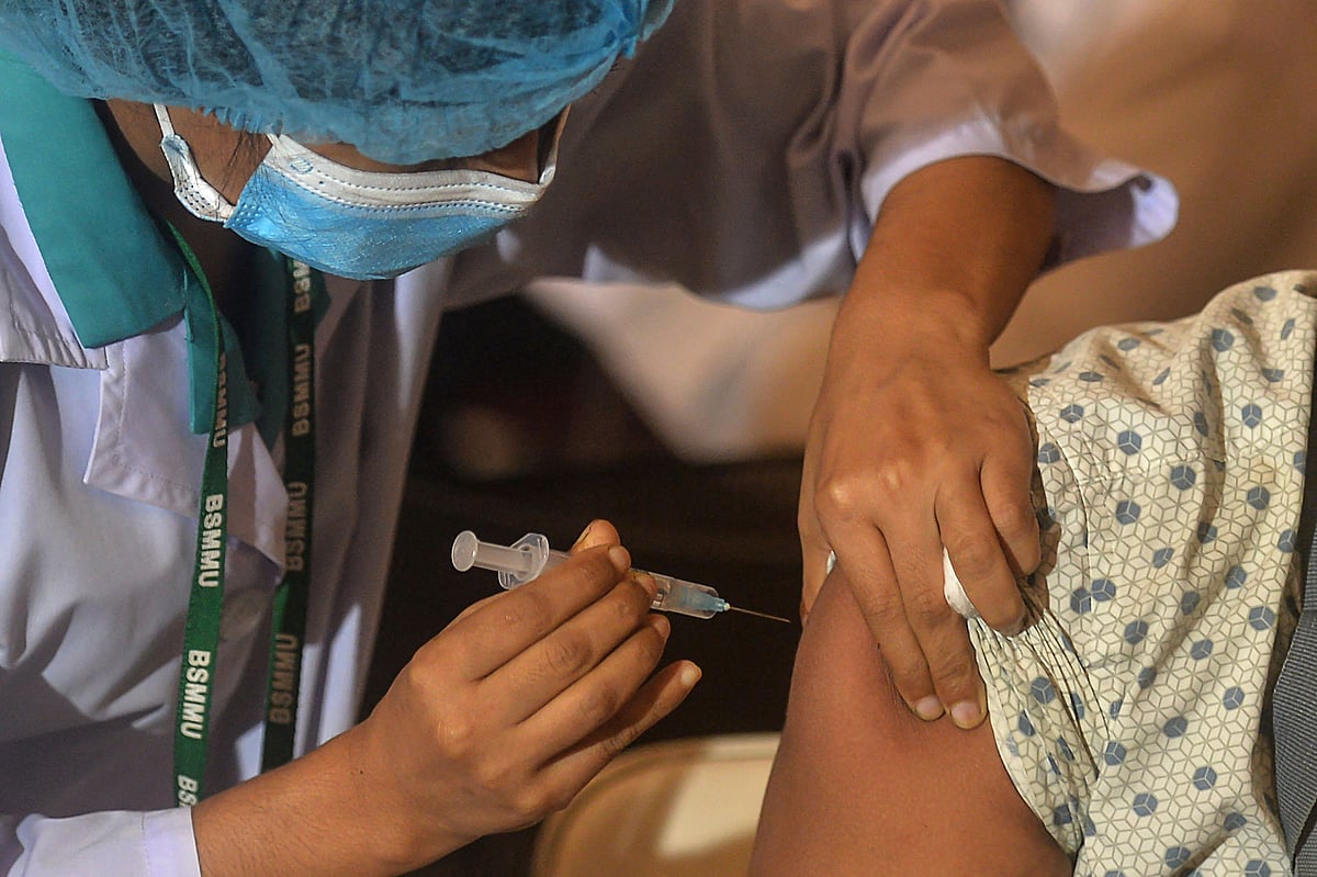 In this photo a health worker inoculates a man with a dose of the Oxford-AstraZeneca Covid-19 vaccine at the Bangabandhu Sheikh Mujib Medical University Hospital (BSMMU), in Dhaka on 22 June 2021.