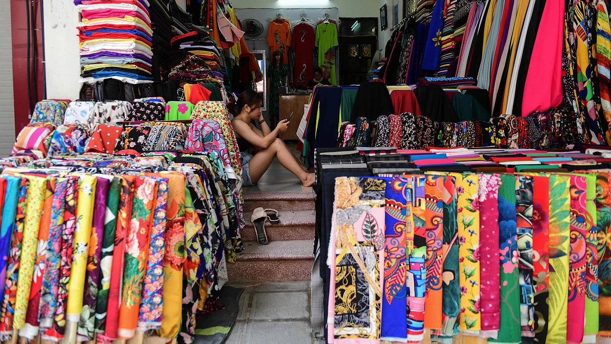 A woman waits for customers inside a fabric shop in Hanoi on 29 June 2021