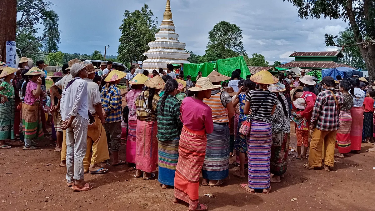 In this photo taken on 25 May 2021 people displaced from recent fighting between government troops and ethnic rebels in their area, wait for food distribution from a volunteer group while taking refuge at a monastery in Namlan town, in Myanmar's eastern Shan state