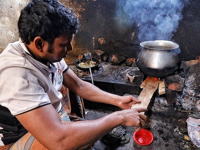 Disruption of gas connection forces a man to use wood for cooking