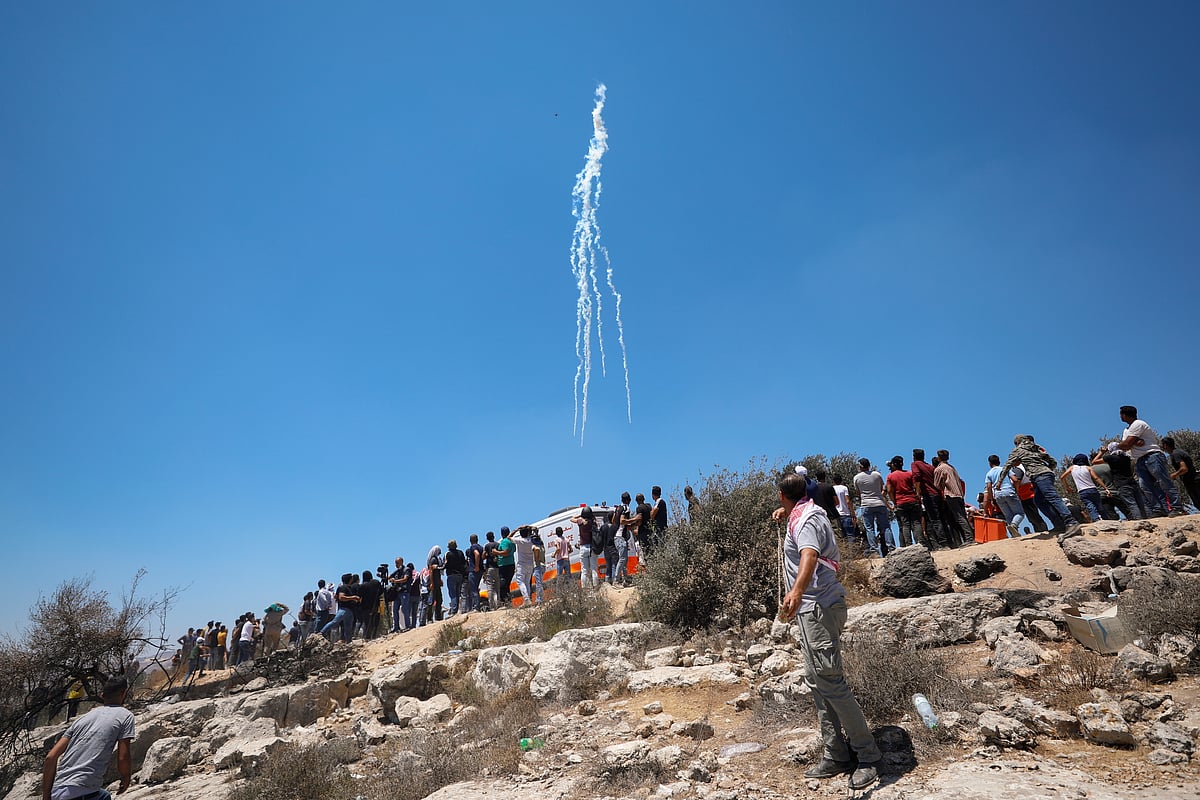 An Israeli drone drops tear gas grenades to disperse Palestinian demonstrators during a protest against Israeli settlements, in Beita, in the Israeli-occupied West Bank 9 July, 2021