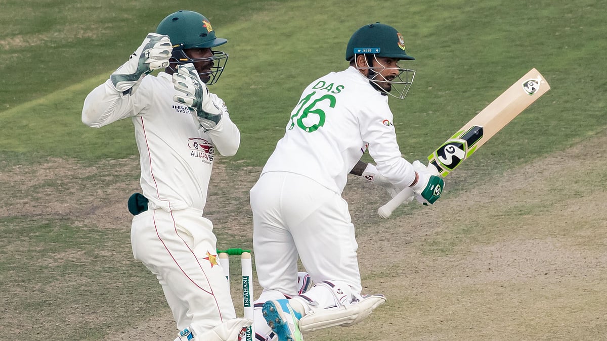 Bangladesh's Liton Das (R) watches the ball after playing a shot as Zimbabwe's Regis Chakabva (L) looks on during the first day of the Test cricket match between Zimbabwe and Bangladesh at the Harare Sports Club in Harare on 7 July 2021
