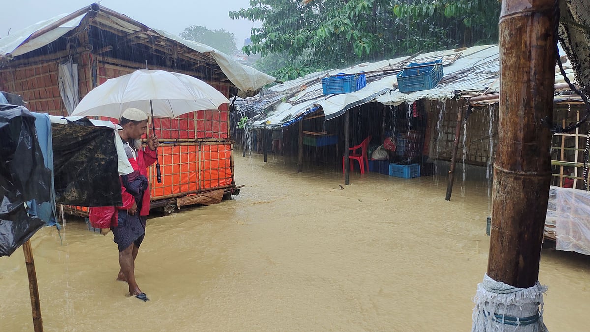 A man walks in a flooded street after heavy monsoon rains triggered flooding at Kutapalong refugee camp, in Cox's Bazar, Bangladesh on 27 July 2021 in this picture obtained from social media