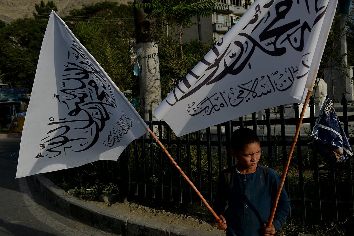 A boy carries Taliban flags to sell at the Karte Mamorin area of Kabul city, Kabul on 22 August 2021
