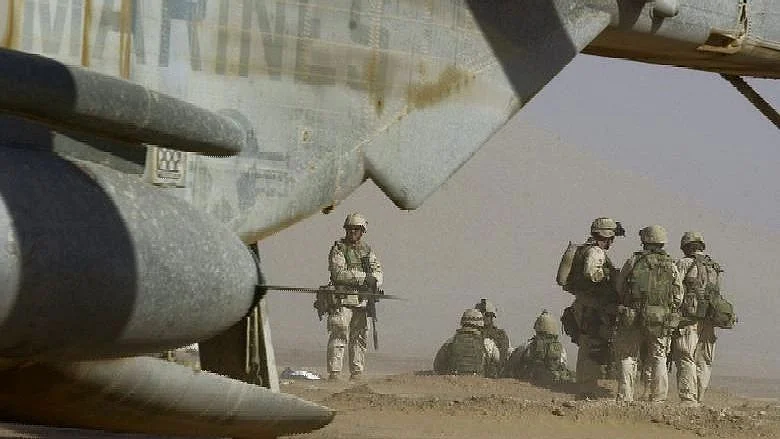 Marines prepare to board a waiting helicopter at Camp Rhino in southern Afghanistan, 10 December, 2001. The Marines were continuing their mission of interdicting avenues of escape for al-Qaeda forces from Kandahar