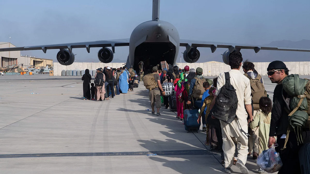 This handout photo courtesy ot the US Air Force shows US Air Force loadmasters and pilots assigned to the 816th Expeditionary Airlift Squadron, load passengers aboard a US Air Force C-17 Globemaster III in support of the Afghanistan evacuation at Hamid Karzai International Airport (HKIA), Afghanistan on 24 August, 2021