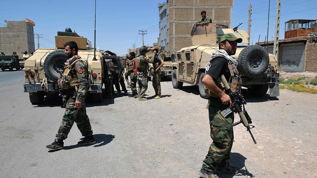 In this picture taken on 1 August 2021, Afghan National Army commando forces walk along a road amid ongoing fighting between Taliban and Afghan security forces in the Enjil district of Herat province