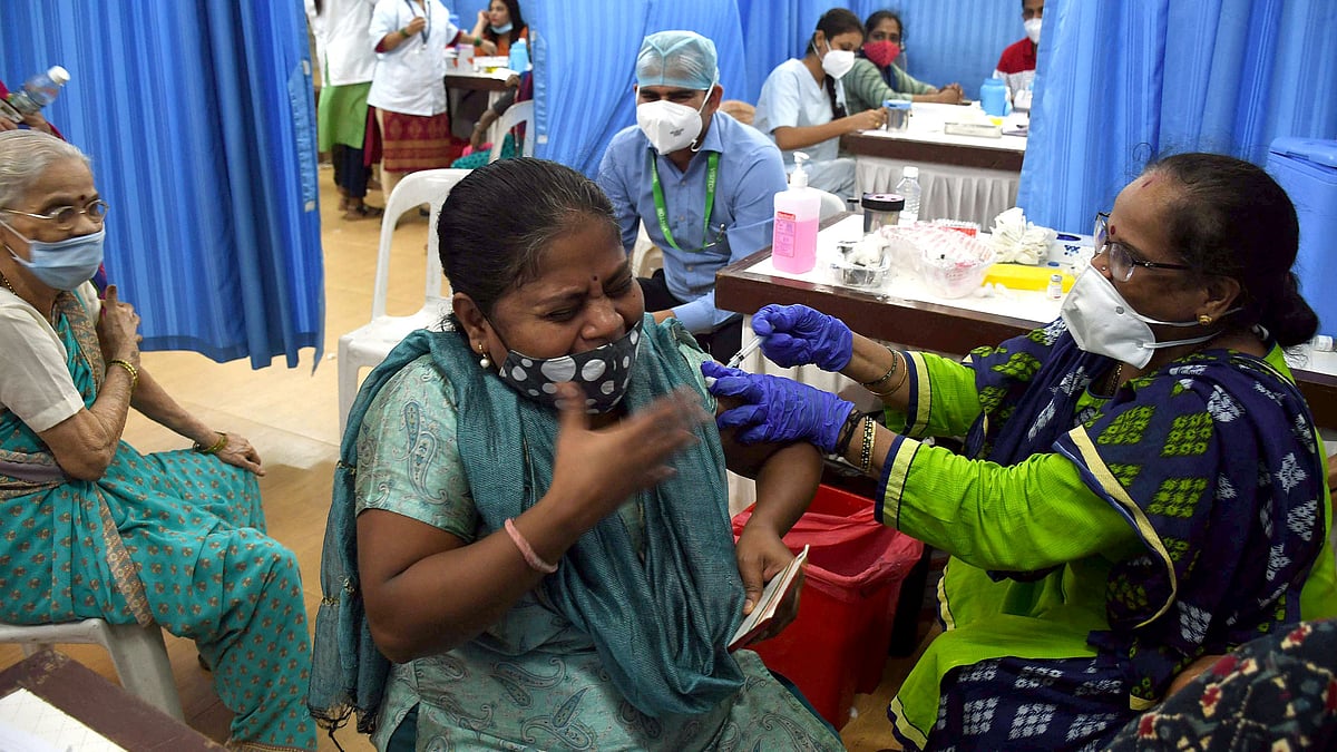 A beneficiary reacts as she receives a dose of the Covid-19 vaccine, at Lalbaug Raja Prabodhini, in Mumbai on 11 August 2021