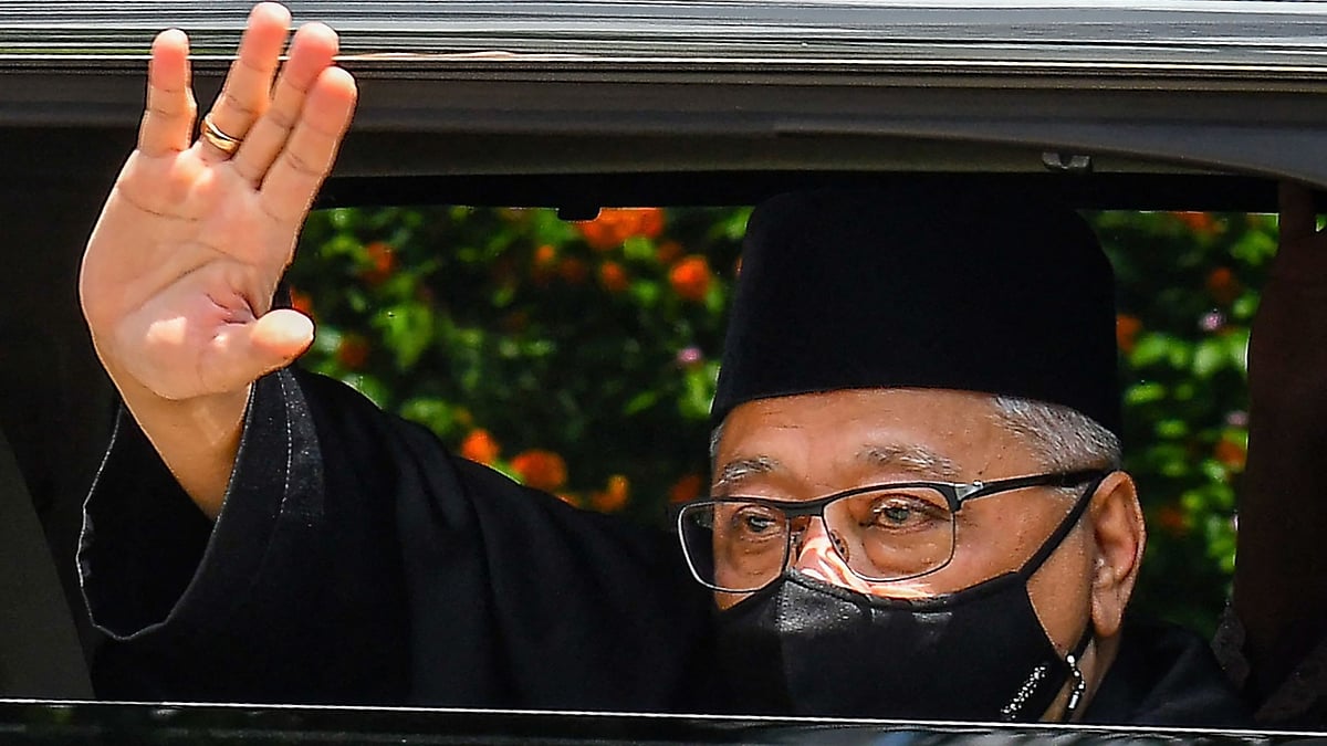 This handout photo from Malaysia's Department of Information taken and released on 21 August 2021 shows Malaysia's incoming Prime Minister Ismail Sabri Yaakob waving as he leaves his house on the way to taking the oath of office to become the country's new leader in Kuala Lumpur.