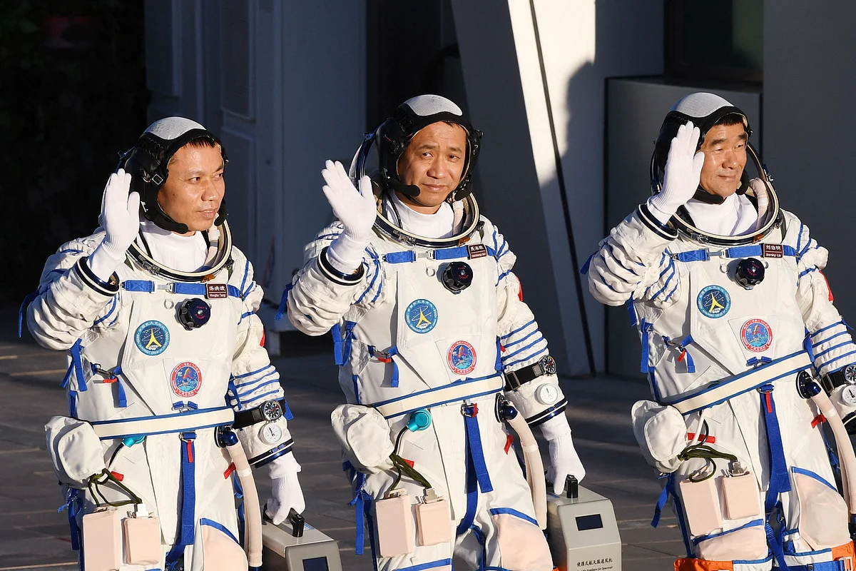 This file photo taken on 17 June, 2021 shows astronauts Nie Haisheng (C), Liu Boming (R) and Tang Hongbo waving during a departure ceremony before boarding the Shenzhou-12 spacecraft on a Long March-2F carrier rocket at the Jiuquan Satellite Launch Centre in the Gobi desert in northwest China