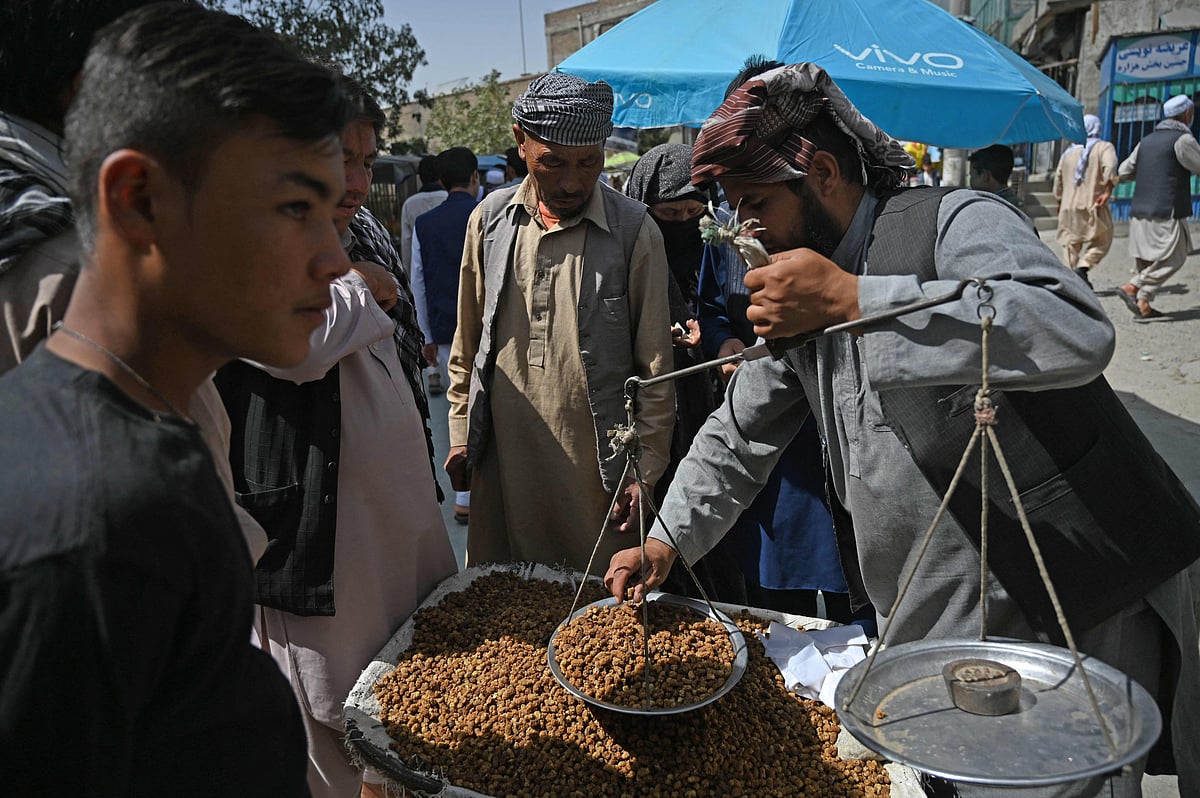 Members of the Hazara community buy dry mulberry at a market on the outskirts of Kabul on 10 September 2021