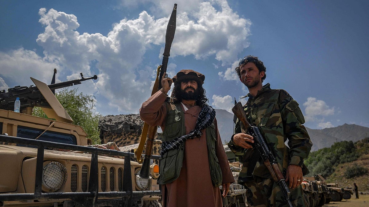 Afghan armed men supporting the Afghan security forces against the Taliban stand with their weapons and Humvee vehicles at Parakh area in Bazarak, Panjshir province on 19 August 2021.