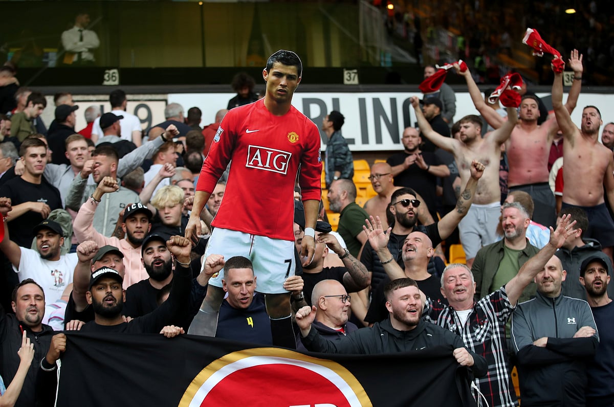 Manchester United fans celebrate with a cardboard cut out of Cristiano Ronaldo