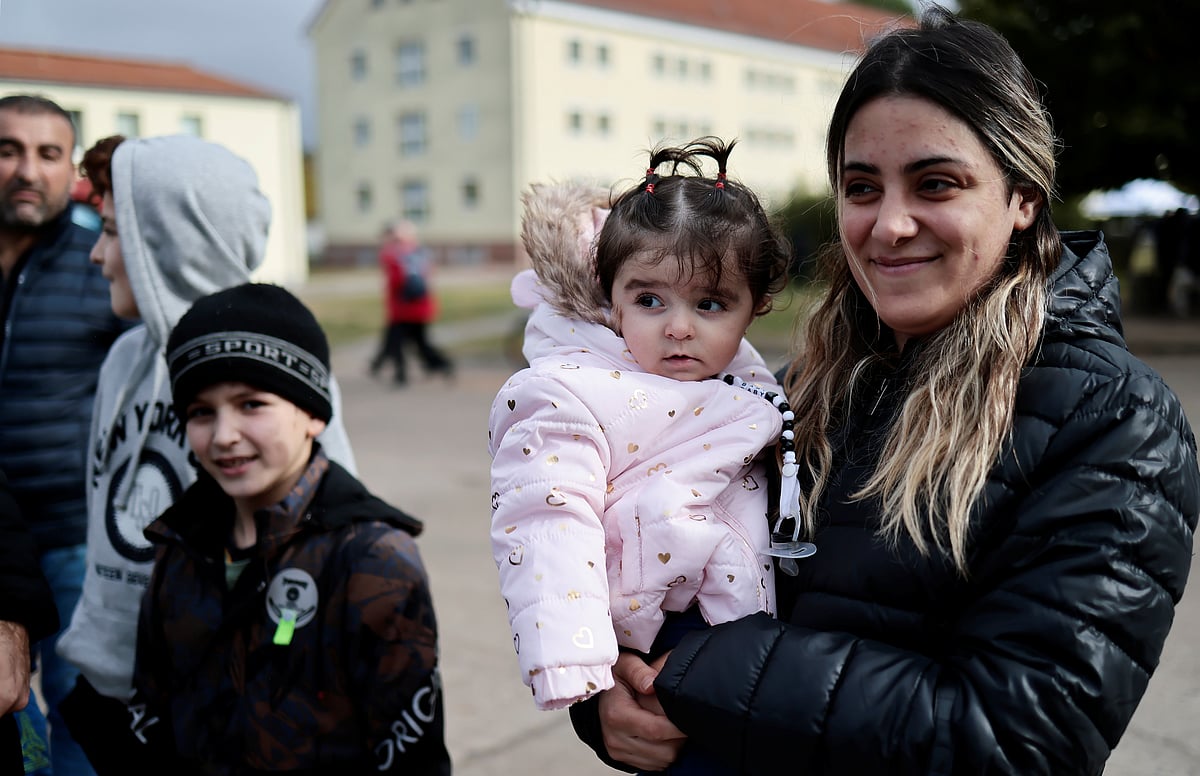 A woman holds her kid at a camp in Eisenhuettenstadt, Germany, 14 October 2021