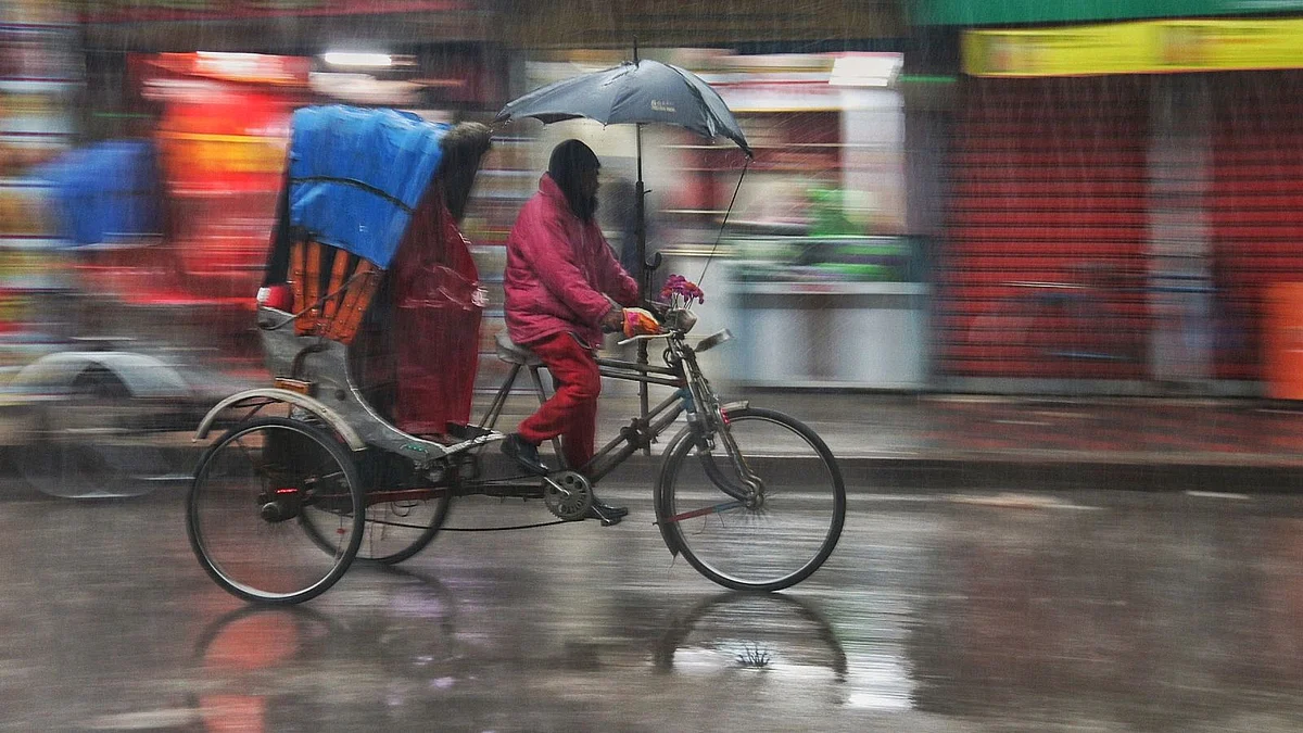 A rickshaw puller rushing with his vehicle in the rain at Picture Palace intersection in Khulna