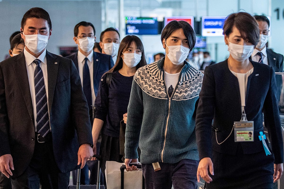 Japan’s former princess Mako Komuro (C), the elder daughter of Prince Akishino and Princess Kiko, and her husband Kei Komuro (2nd R) walk to their departure gate for their flight to New York at Tokyo's Haneda international airport on 14 November, 2021