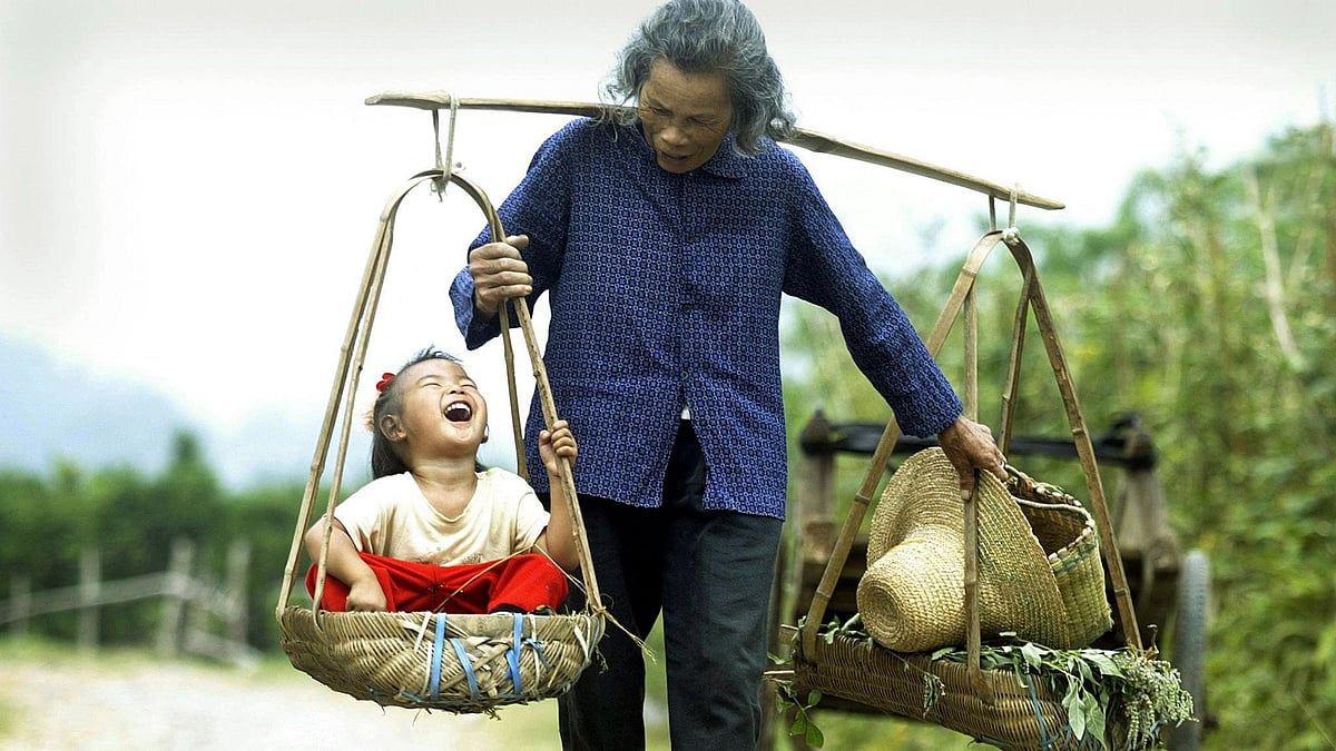 In this file photo taken on 1 October, 2003 a grandmother carries her laughing grand-daugher outside the tourist mecca of Yangshou in southern China