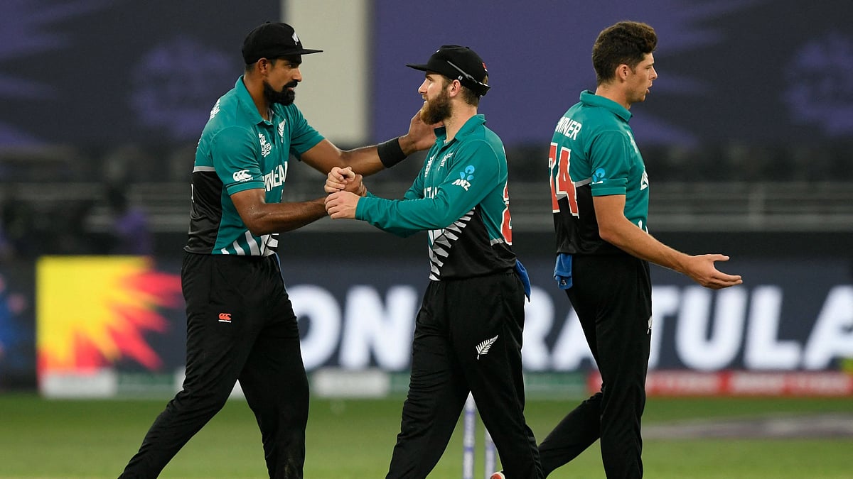 New Zealand's captain Kane Williamson (C) celebrates with teammates Ish Sodhi (L) and Mitchell Santner at the end of the ICC men’s Twenty20 World Cup cricket match between New Zealand and Scotland at the Dubai International Cricket Stadium in Dubai on 3 November 2021.
