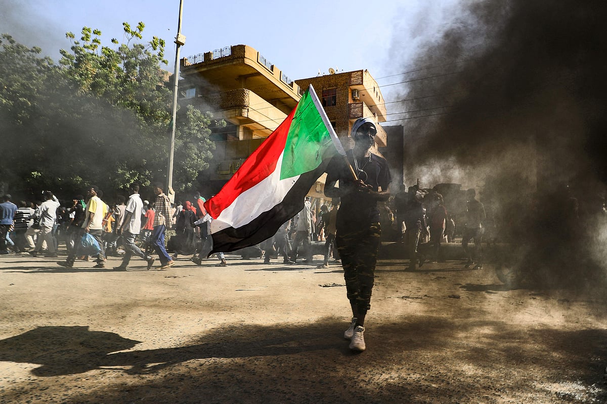 A man waves a Sudanese national flag as people gather for a demonstration in the centre of Sudan's capital Khartoum on 30 November 2021 while protesting against a deal that saw the civilian prime minister reinstated after the military coup in October.
