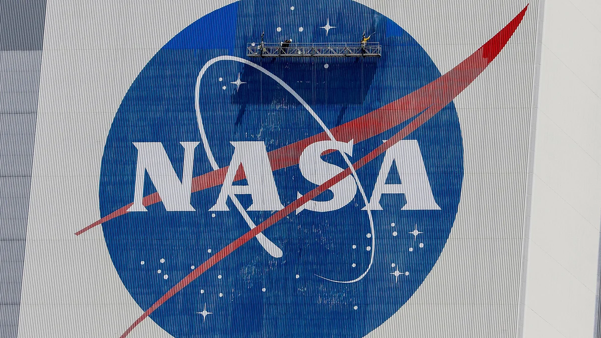 Workers pressure wash the logo of NASA on the Vehicle Assembly Building before SpaceX will send two NASA astronauts to the International Space Station aboard its Falcon 9 rocket, at the Kennedy Space Center in Cape Canaveral, Florida, US on 19 May 2020.