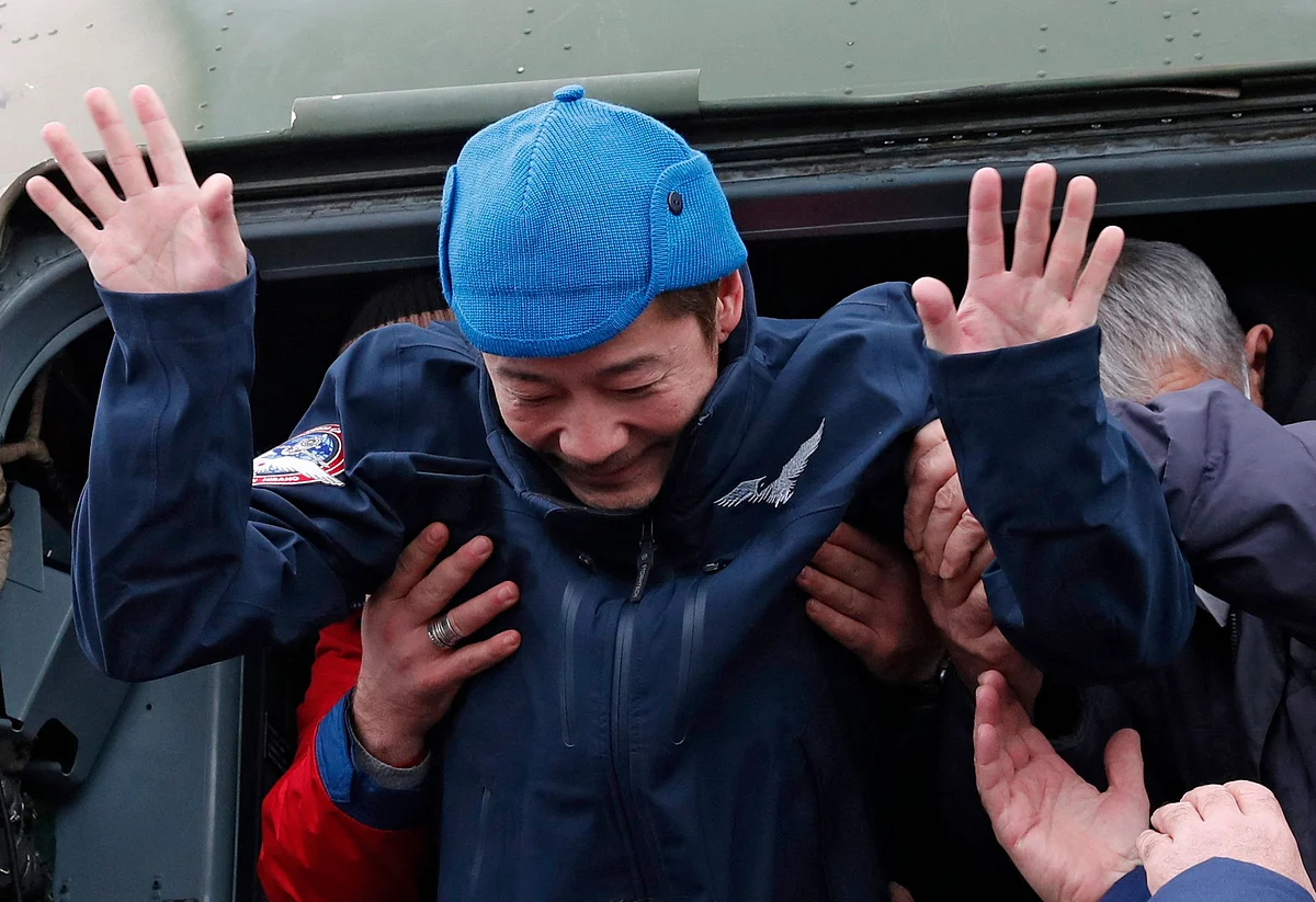 Japanese billionaire Yusaku Maezawa is helped to disembark from a helicopter as he arrives at Zhezkazgan airport after returning from the International Space Station (ISS) on the Soyuz MS-20 space capsule, in Zhezkazgan, Kazakhstan, December 20, 2021