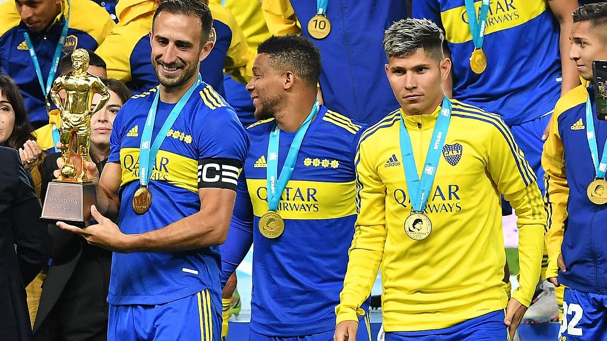 Argentina's Boca Juniors Marcelo Weigandt (L) holds the Maradona Cup trophy following a friendly football match between Spain's Barcelona and Argentina's Boca Juniors part of the Maradona Cup at the Mrsool Park Stadium in the Saudi capital Riyadh on 14 December, 2021