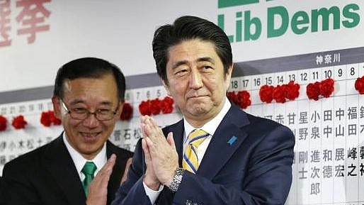 Japan's PM Abe, also leader of the ruling Liberal Democratic Party (LDP), claps during an election night event at the LDP headquarters