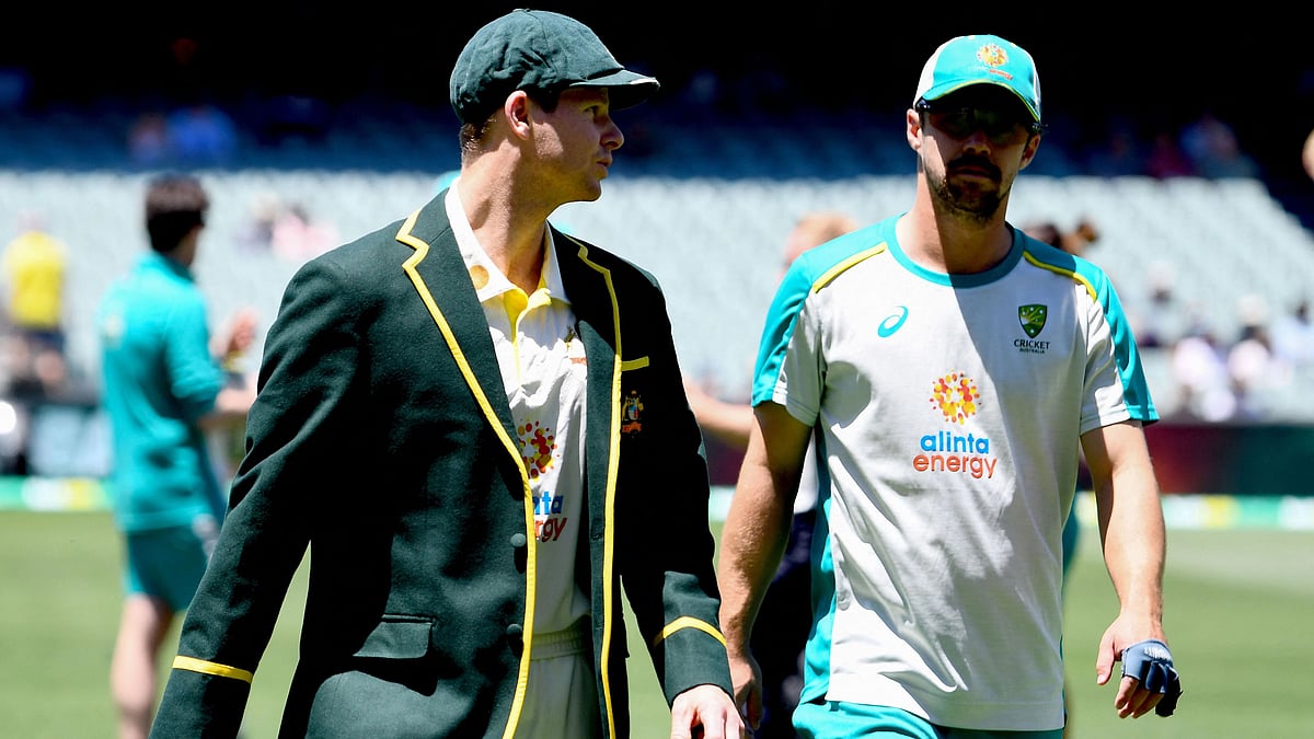 Australia's cricket team new captain Steve Smith (L) walks off the field with a teammate Travis Head prior to the second Ashes Test match against England in Adelaide on 16 December 2021
