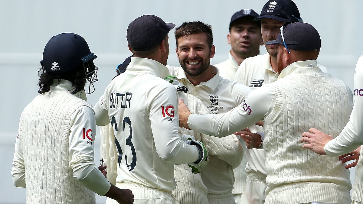 England's Mark Wood (C) celebrates the wicket of Australia's batsman Marnus Labuschagne (not pictured) with teammates on day two of the third Ashes cricket Test match between Australia and England in Melbourne on 27 December, 2021