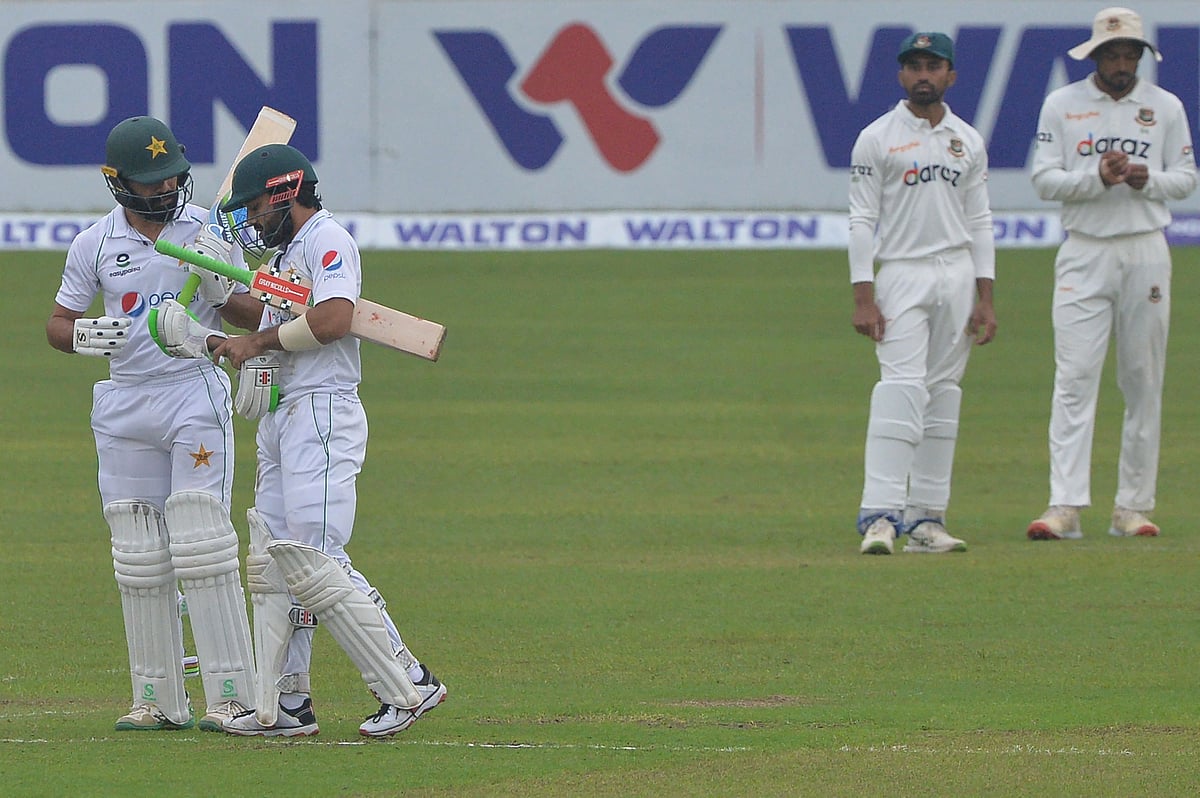 Pakistan's Fawad Alam (L) speaks with teammate Mohammad Rizwan (2L) during the fourth day of the second Test cricket match between Bangladesh and Pakistan at the Sher-e-Bangla National Cricket Stadium in Dhaka on 7 December, 2021