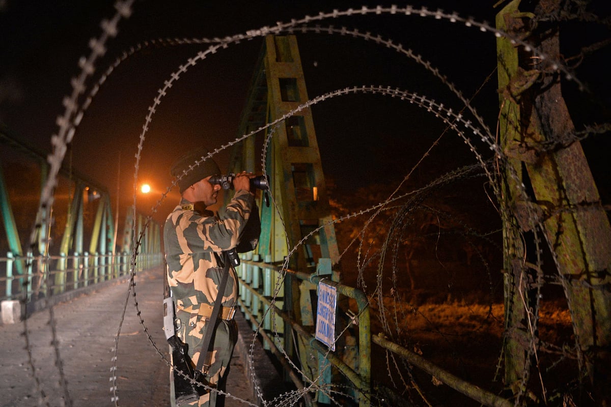 In this picture taken on 30 December 2021, Indian Border Security Force (BSF) soldiers patrol along an unfenced area at the India Bangladesh border outpost in Phansidewa village, about 35km from Siliguri