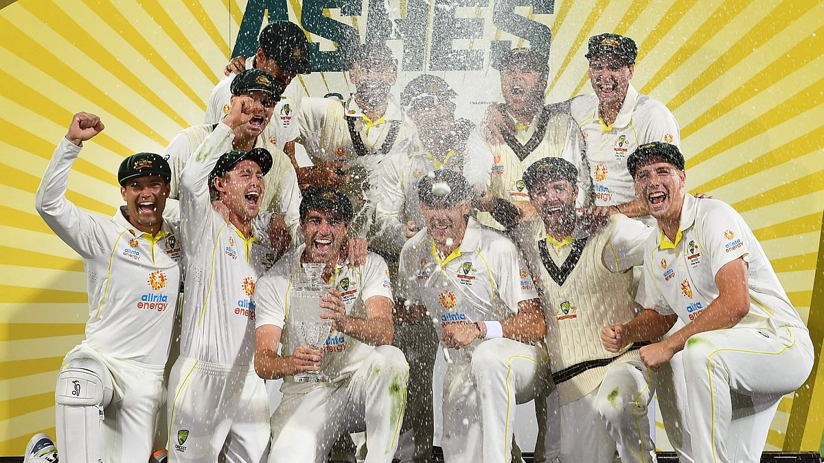 Australia's players celebrates with the trophy after defeating England on the third day of the fifth Ashes cricket Test match in Hobart on 16 January 2022.