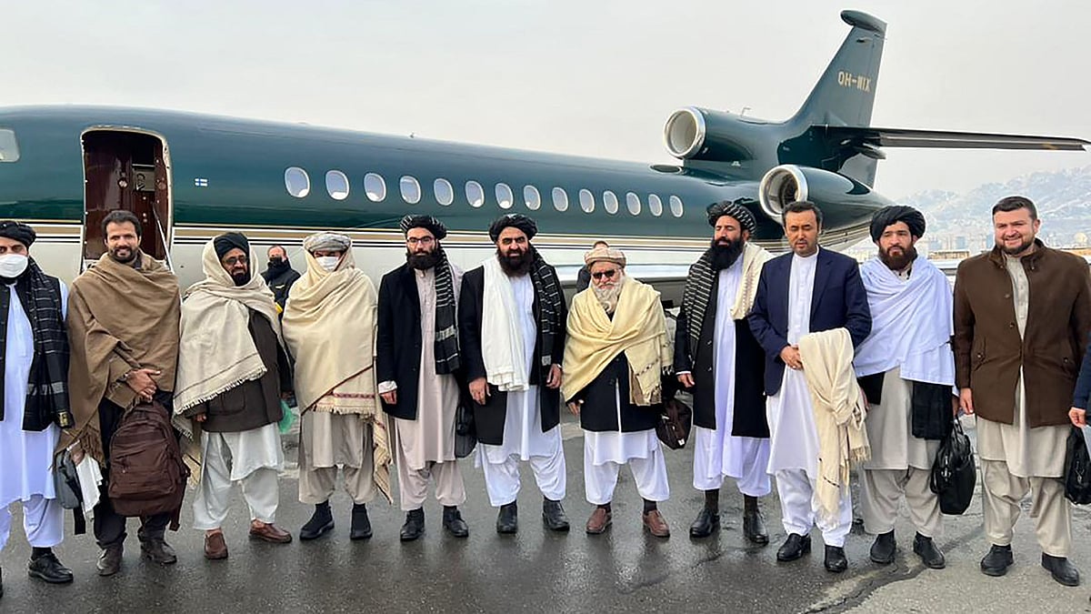 This handout photograph released by the Afghan Taliban and taken on 22 January, 2022 shows Afghanistan’s Foreign Minister Amir Khan Muttaqi (C), Taliban senior official member Anas Haqqani (R) and delegates posing for pictures before departing to Oslo, at the Kabul airport in Kabul