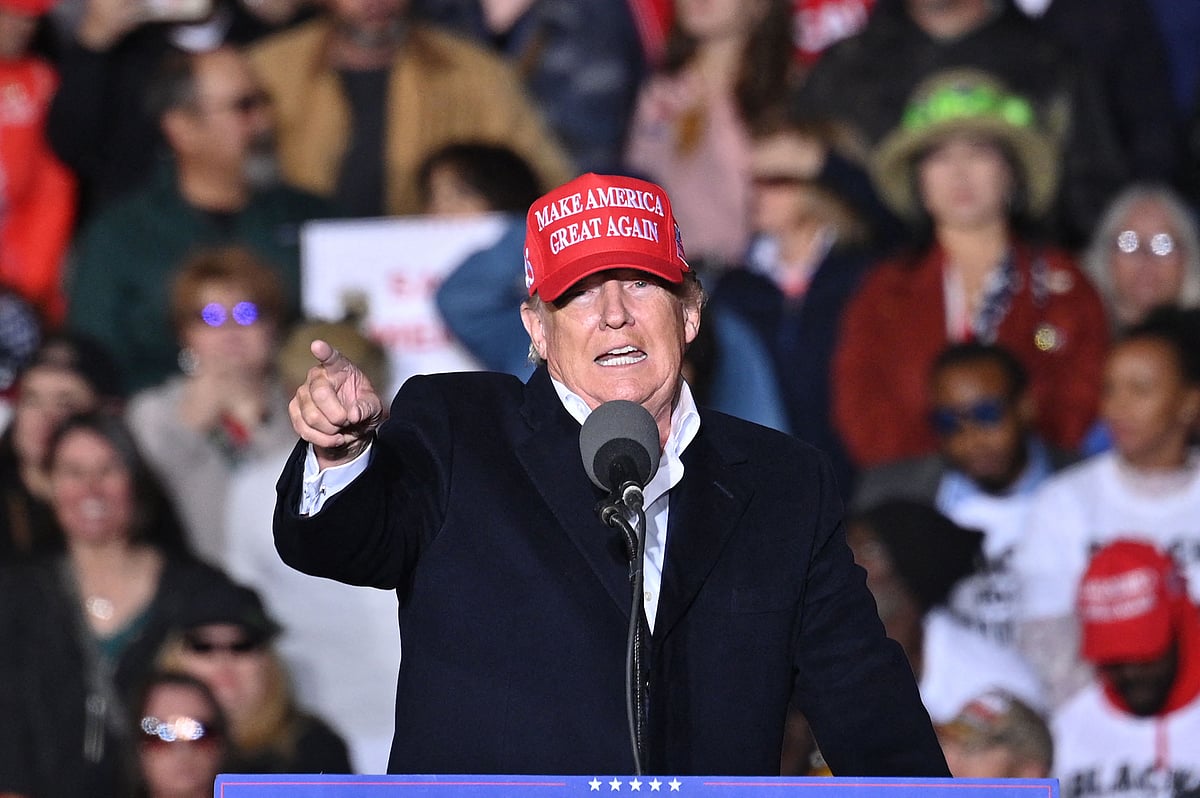 Former US President Donald Trump throws "Save America" hats to his suporters during a rally at the Canyon Moon Ranch festival grounds in Florence, Arizona, southeast of Phoenix, on 15 January, 2022