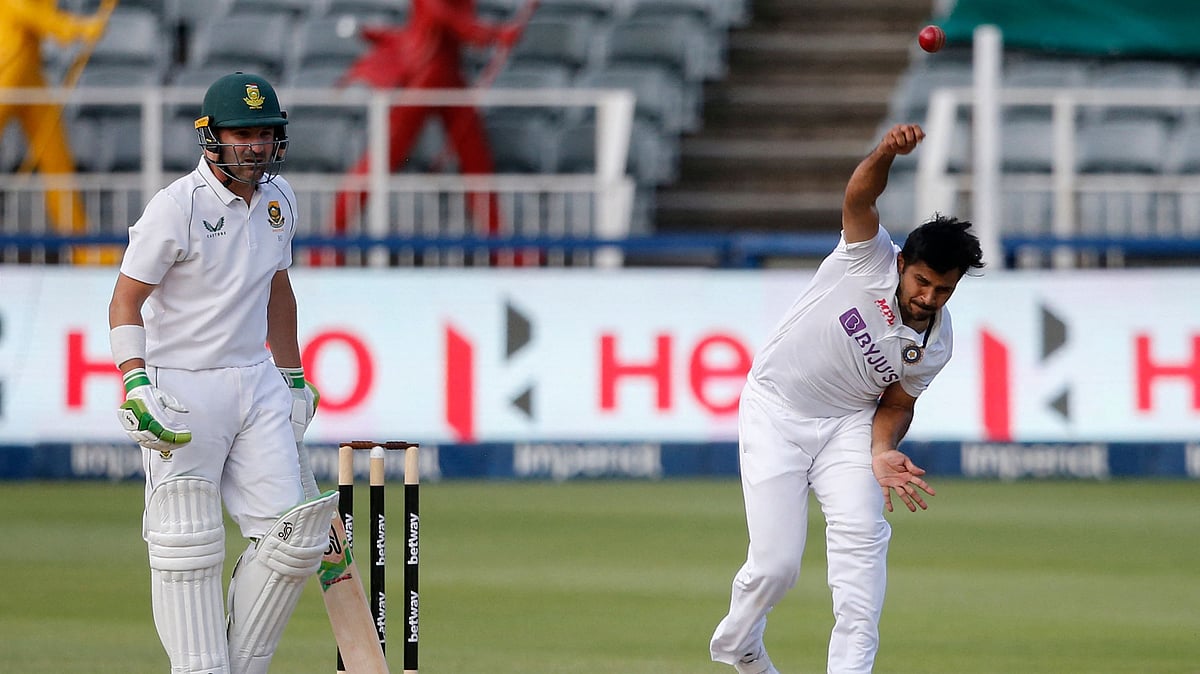 India's Shardul Thakur (R) delivers a ball as South Africa's Dean Elgar (L) looks on during the third day of the second Test cricket match between South Africa and India at The Wanderers Stadium in Johannesburg on 5 January 2022.