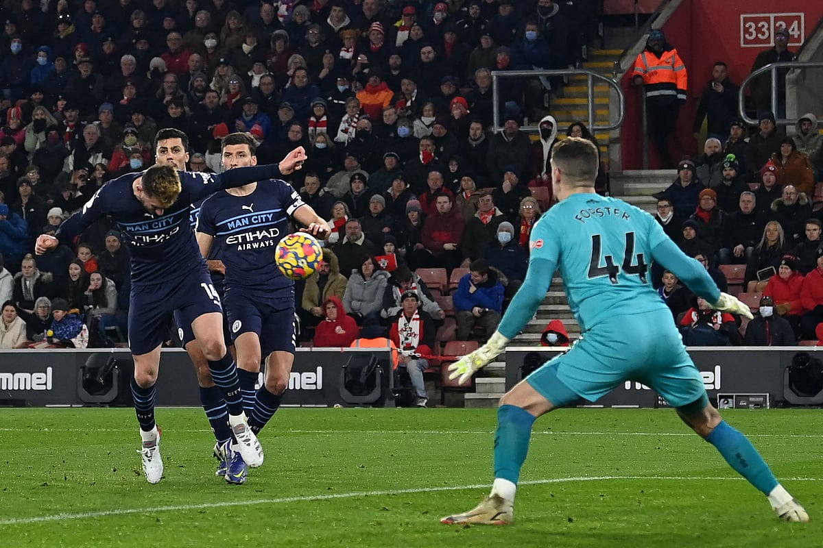 Manchester City's French defender Aymeric Laporte (L) heads home their first goal during the English Premier League football match between Southampton and Manchester City at St Mary's Stadium in Southampton, southern England on 22 January, 2022