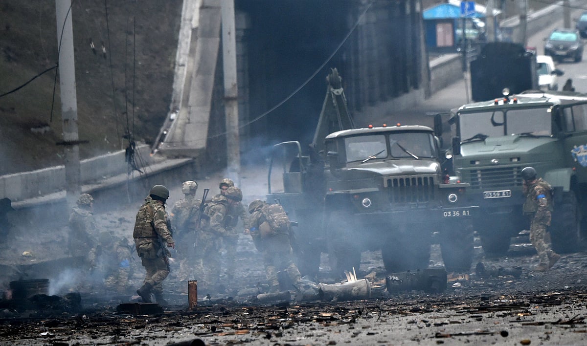Ukrainian service members collect unexploded shells after a fighting with Russian raiding group in the Ukrainian capital of Kyiv in the morning of 26 February, 2022, according to Ukrainian service personnel at the scene