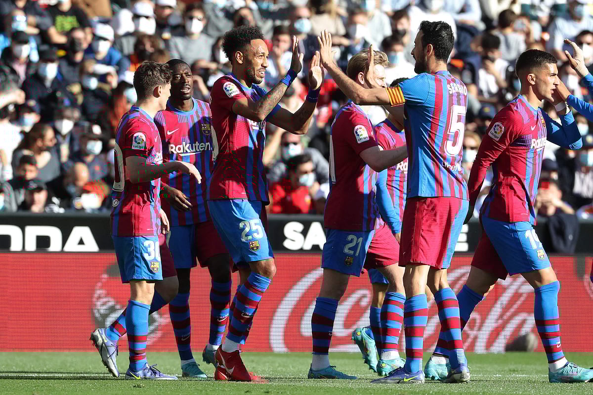 Barcelona's Gabonese midfielder Pierre-Emerick Aubameyang (C) celebrates with teammates after scoring a goal during the Spanish league football match between Valencia CF and FC Barcelona at the Mestalla stadium in Valencia on 20 February, 2022