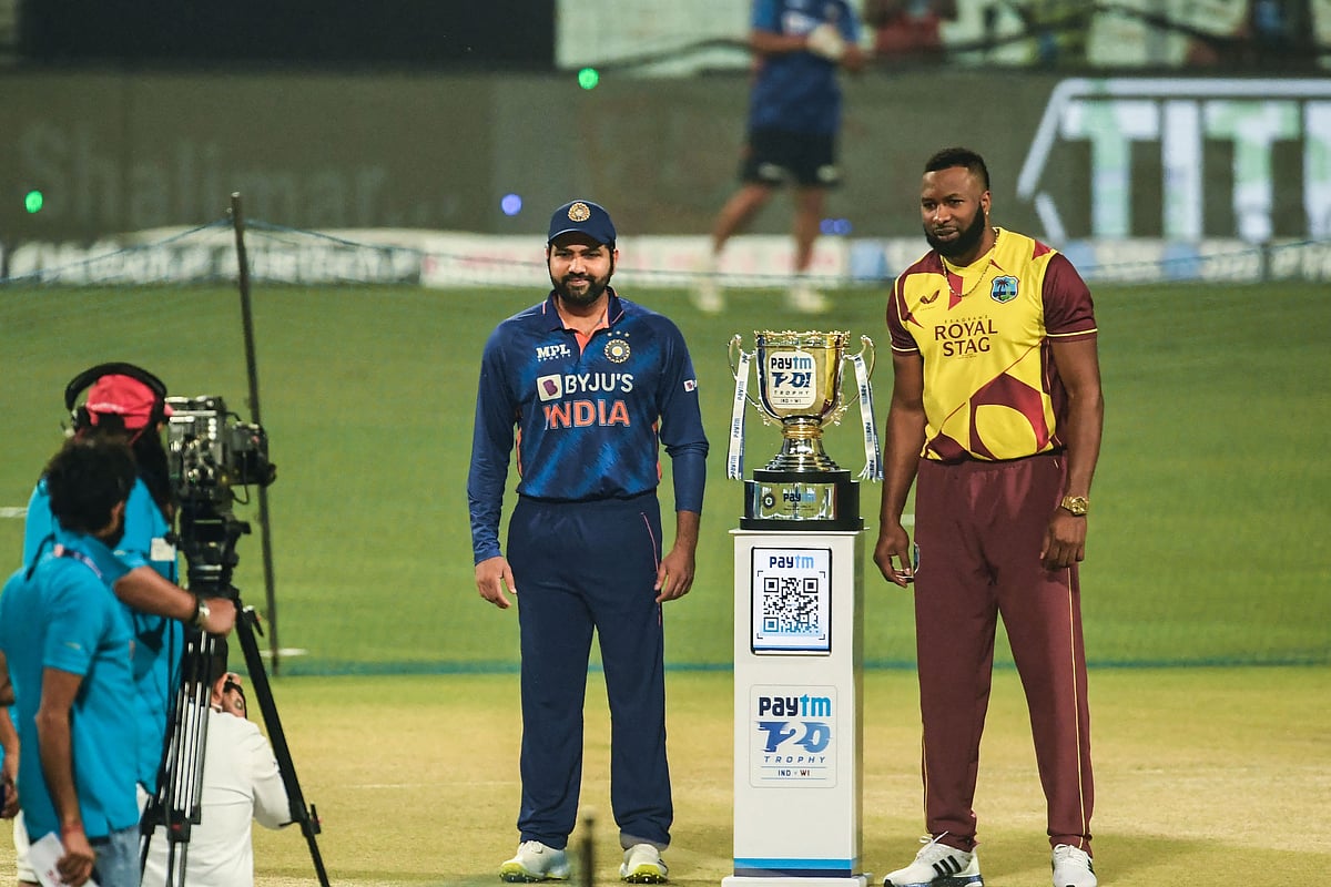 India's captain Rohit Sharma (L) and West Indies' Kieron Pollard (R) pose for pictures with the trophy ahead of the first Twenty20 international cricket match between India and West Indies at the Eden Gardens in Kolkata on 16 February 2022.