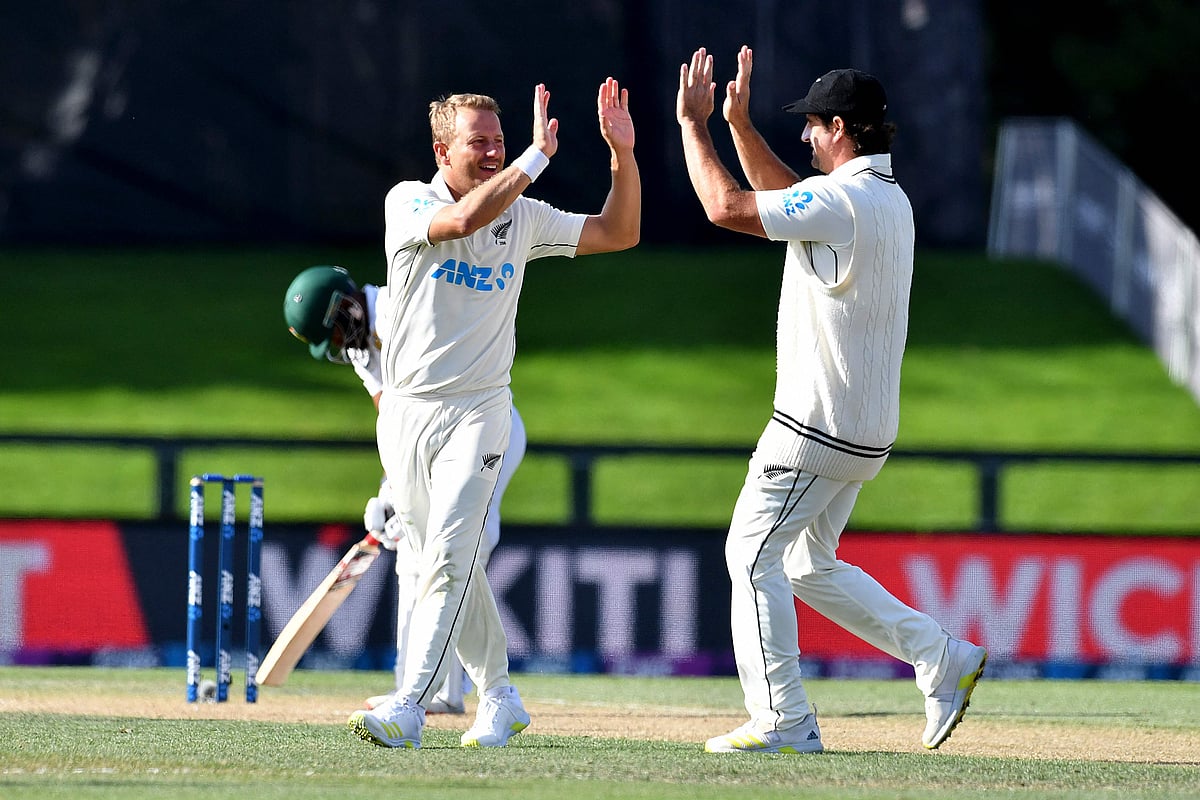 New Zealand's paceman Neil Wagner celebrates the dismissal of South Africa's Temba Bavuma with a teammate Colin de Grandhomme (R) on day three of the second cricket Test match between New Zealand and South Africa at Hagley Oval in Christchurch on 27 February 2022