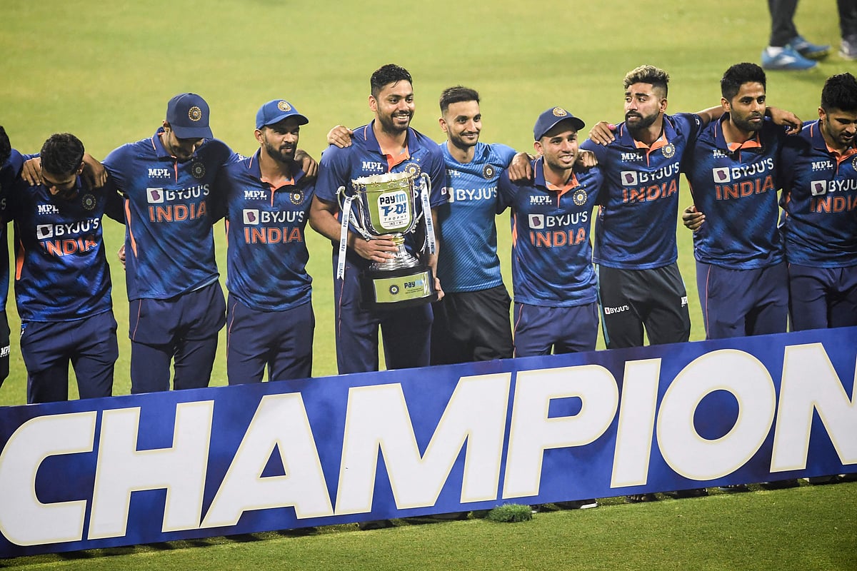 India's players pose for pictures with the trophy after winning the third and final international Twenty20 cricket match against West Indies at the Eden Gardens in Kolkata on 20 February, 2022