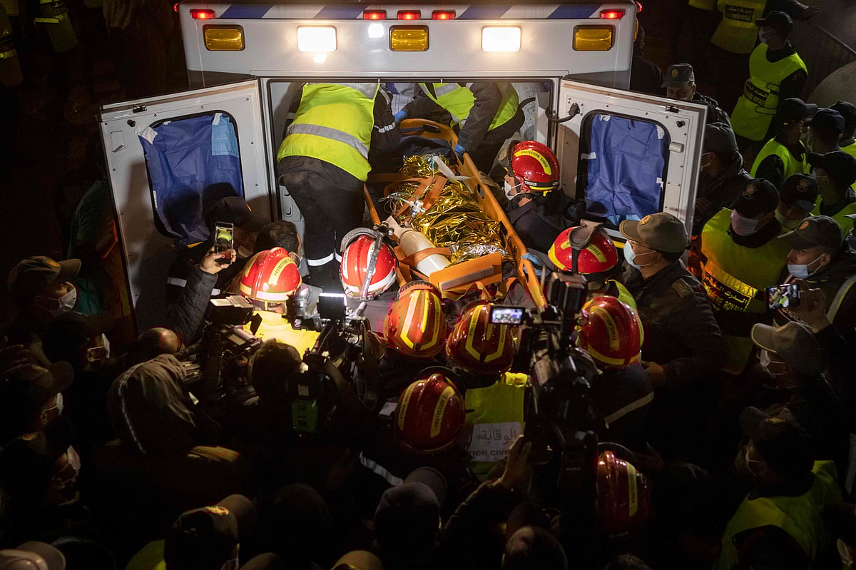 Moroccan emergency services teams carry five-year-old Rayan Oram into an ambulance after pulling him from a well shaft he fell into on February 1, in the remote village of Ighrane in the rural northern province of Chefchaouen on 5 February 2022